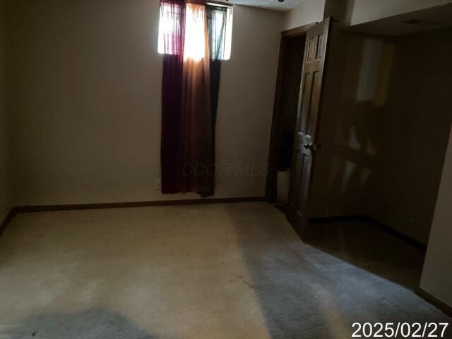 unfurnished bedroom with light colored carpet and baseboards