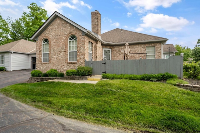 1272 Villa Oaks Ct, Columbus, OH 43230 - view of front of property featuring brick siding, a chimney, a gate, roof with shingles, and asphalt driveway