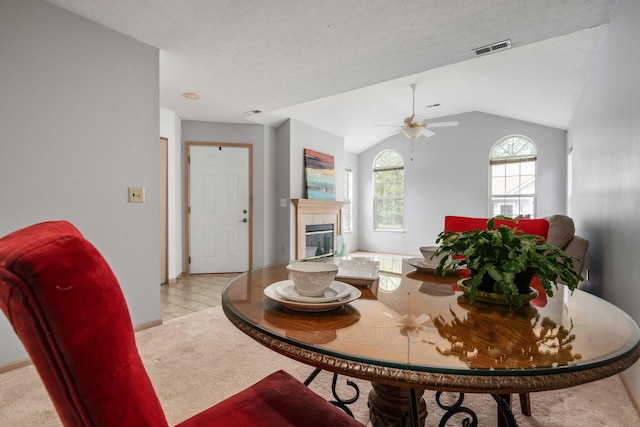 1272 Villa Oaks Ct, Columbus, OH 43230 - dining area featuring light carpet, a tiled fireplace, ceiling fan, lofted ceiling, and baseboards