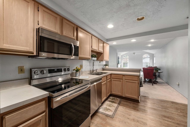 1272 Villa Oaks Ct, Columbus, OH 43230 - kitchen featuring appliances with stainless steel finishes, a sink, a peninsula, light countertops, and a textured ceiling