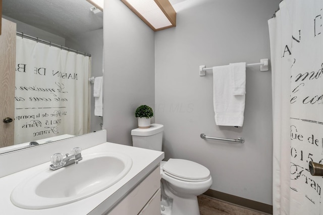 1272 Villa Oaks Ct, Columbus, OH 43230 - full bath with wood finished floors, vanity, toilet, a shower with curtain, and baseboards