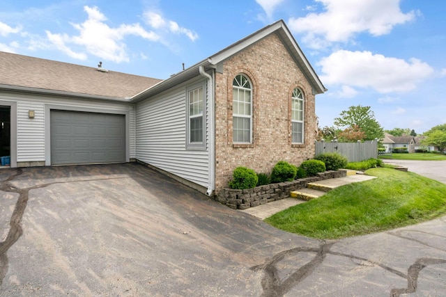 1272 Villa Oaks Ct, Columbus, OH 43230 - view of side of home featuring asphalt driveway, an attached garage, and brick siding