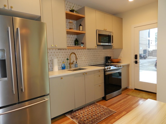 236 E 4th Ave, Columbus, OH 43201 - kitchen with appliances with stainless steel finishes, a sink, open shelves, light countertops, and light wood-style flooring