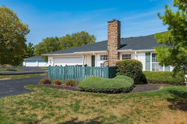 2412 Warm Springs Dr, Hilliard, OH 43026 - view of side of home with a chimney, a garage, roof with shingles, and driveway