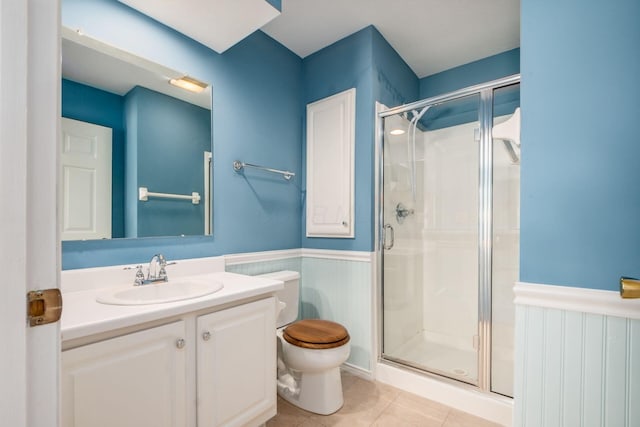2412 Warm Springs Dr, Hilliard, OH 43026 - bathroom with toilet, a wainscoted wall, a shower stall, vanity, and tile patterned floors