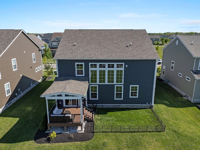 back of house with a wooden deck, a residential view, and roof with shingles
