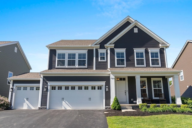 view of front facade with a porch, driveway, and a garage