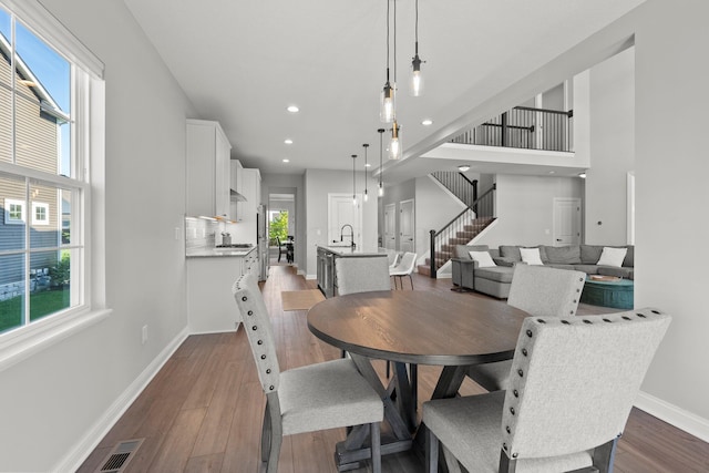 dining space featuring stairway, baseboards, wood finished floors, and recessed lighting