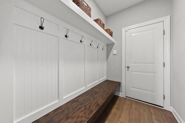 mudroom featuring dark wood-type flooring and baseboards