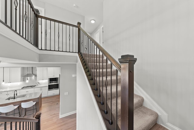stairway with wood finished floors and baseboards