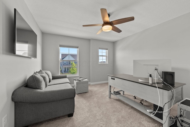 office space featuring a ceiling fan, carpet flooring, baseboards, and a textured ceiling