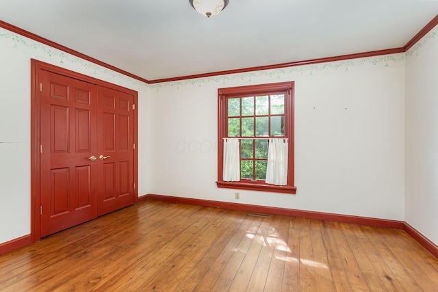 26976 Jackson Rd, Circleville, OH 43113 - unfurnished bedroom with baseboards, light wood-style flooring, crown molding, and a closet