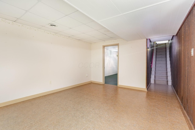 26976 Jackson Rd, Circleville, OH 43113 - spare room featuring light flooring, baseboards, a paneled ceiling, and wooden walls