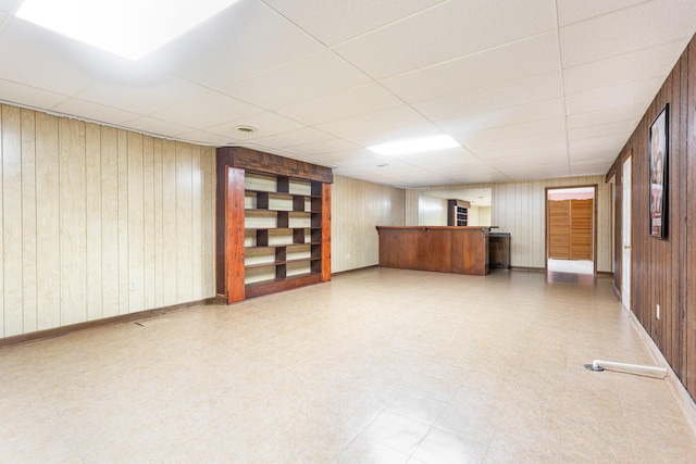 26976 Jackson Rd, Circleville, OH 43113 - finished basement with tile patterned floors, bar, wood walls, a drop ceiling, and baseboards