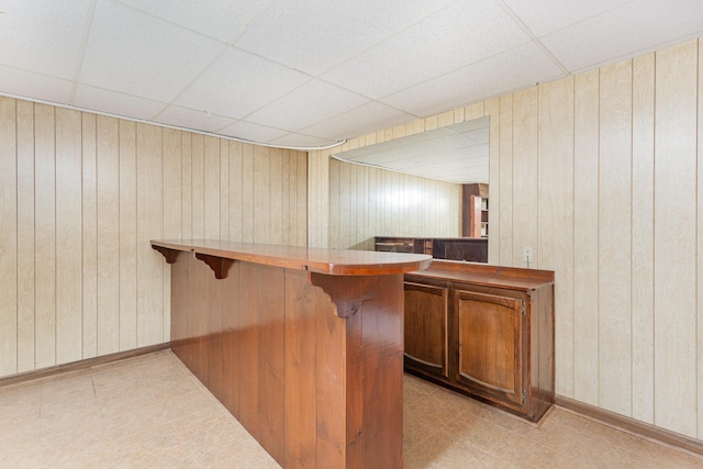 26976 Jackson Rd, Circleville, OH 43113 - indoor dry bar featuring a paneled ceiling, wood walls, light tile patterned floors, and baseboards