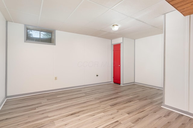 26976 Jackson Rd, Circleville, OH 43113 - below grade area with light wood finished floors, a paneled ceiling, and baseboards
