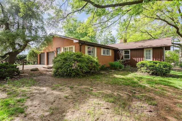 26976 Jackson Rd, Circleville, OH 43113 - view of front of home featuring brick siding, a garage, board and batten siding, fence, and driveway