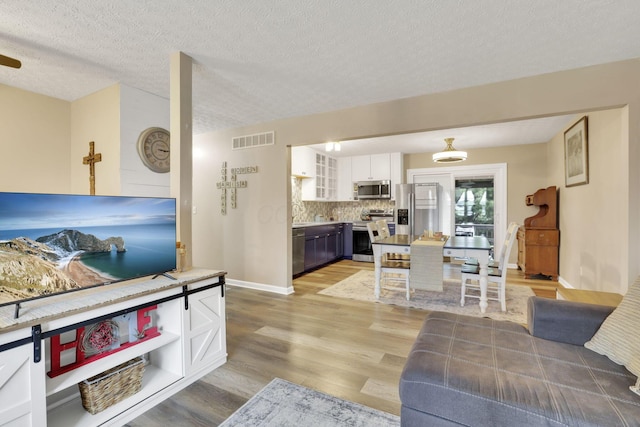 4292 Nipigon Dr, Columbus, OH 43207 - living room featuring light wood finished floors, a textured ceiling, and baseboards