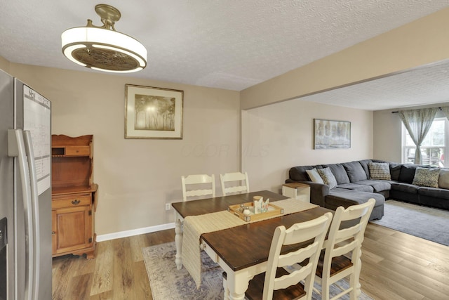 4292 Nipigon Dr, Columbus, OH 43207 - dining area with light wood-type flooring, a textured ceiling, and baseboards