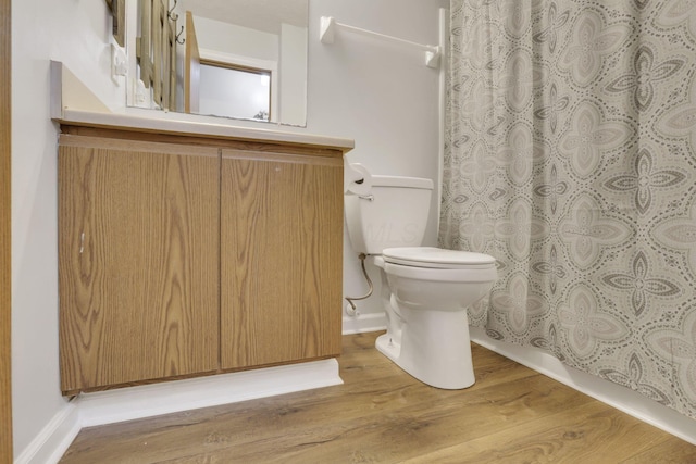 4292 Nipigon Dr, Columbus, OH 43207 - bathroom with toilet, wood finished floors, a shower with curtain, vanity, and baseboards