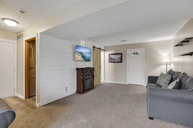 4292 Nipigon Dr, Columbus, OH 43207 - carpeted living room with a textured ceiling, a barn door, and baseboards