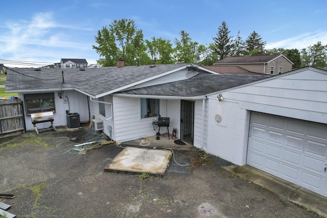 4969 Lockbourne Rd, Columbus, OH 43207 - view of front of home with a shingled roof, central AC unit, a chimney, and a garage