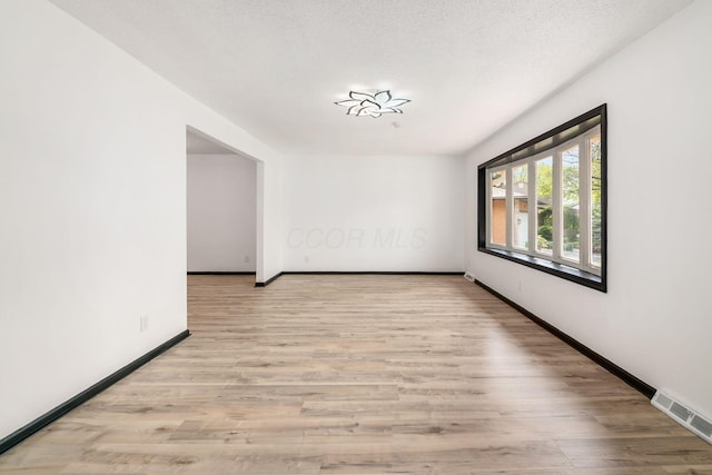 unfurnished room featuring light wood-type flooring and baseboards