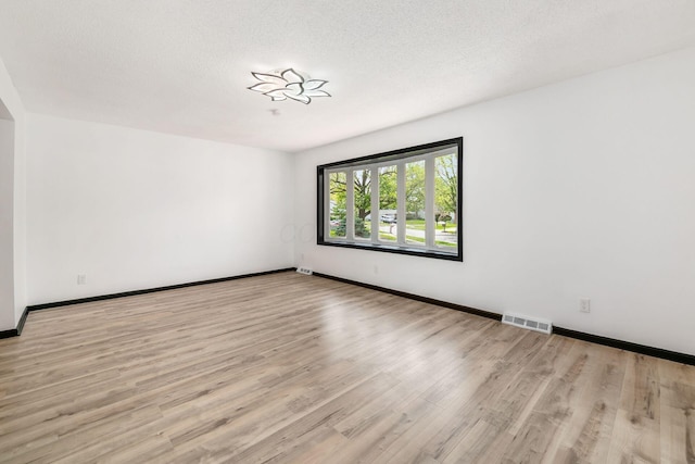spare room with light wood-style floors and baseboards
