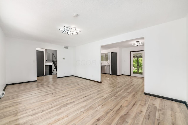 unfurnished living room featuring light wood-type flooring and baseboards