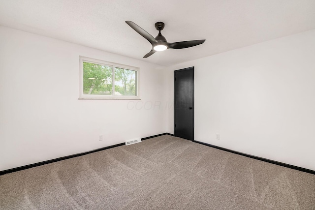 carpeted empty room with a ceiling fan and baseboards