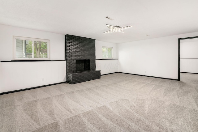 unfurnished living room featuring a brick fireplace, carpet, and baseboards