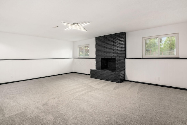 unfurnished living room with a brick fireplace and carpet floors