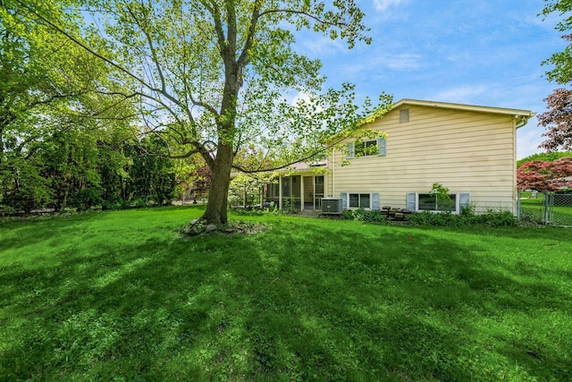 view of yard with a sunroom and central AC unit
