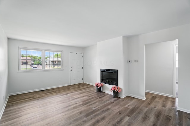 273 E Alcott Rd, Columbus, OH 43207 - unfurnished living room featuring wood finished floors, a glass covered fireplace, and baseboards