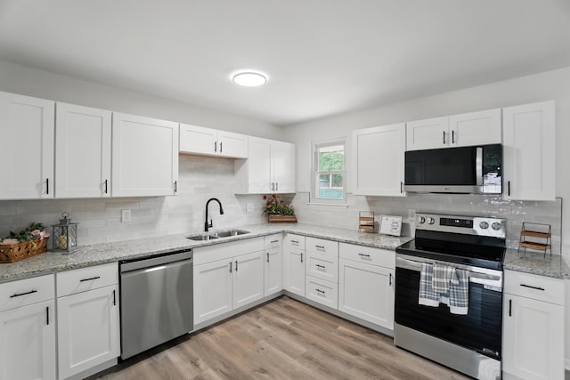 273 E Alcott Rd, Columbus, OH 43207 - kitchen with appliances with stainless steel finishes, a sink, white cabinets, tasteful backsplash, and light stone countertops