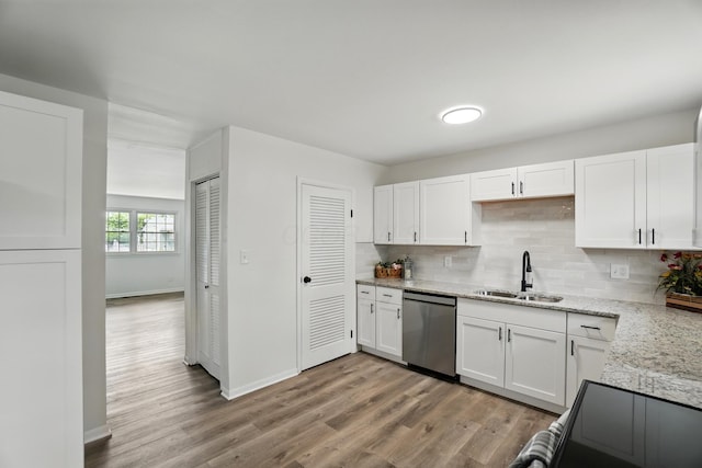 273 E Alcott Rd, Columbus, OH 43207 - kitchen with stainless steel dishwasher, a sink, white cabinetry, light wood finished floors, and backsplash