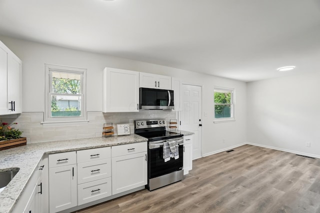273 E Alcott Rd, Columbus, OH 43207 - kitchen with electric stove, tasteful backsplash, white cabinetry, light stone countertops, and light wood-style floors