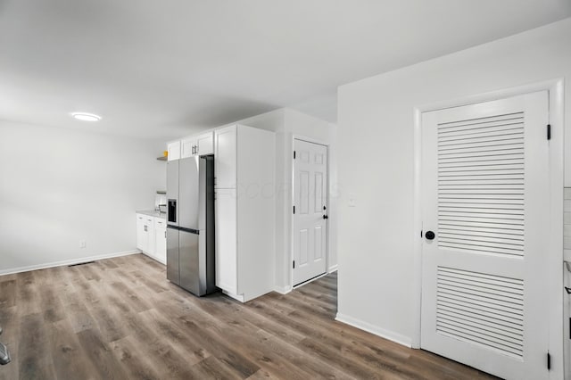 273 E Alcott Rd, Columbus, OH 43207 - kitchen with stainless steel fridge, wood finished floors, white cabinets, and baseboards