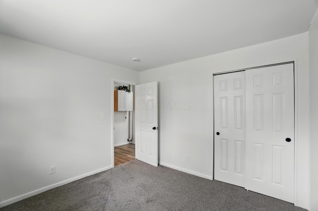 273 E Alcott Rd, Columbus, OH 43207 - unfurnished bedroom with dark carpet, baseboards, and a closet