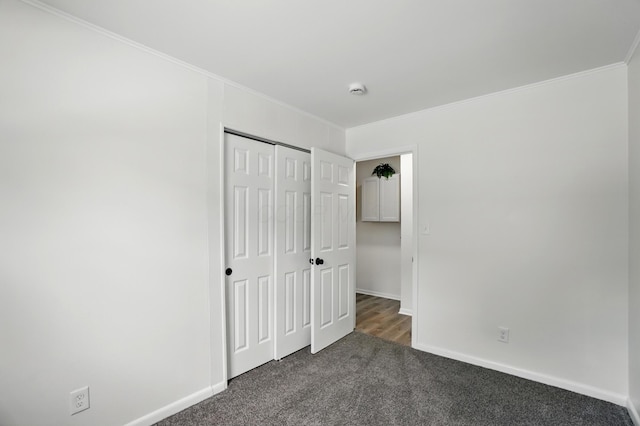 273 E Alcott Rd, Columbus, OH 43207 - unfurnished bedroom featuring dark carpet, crown molding, baseboards, and a closet