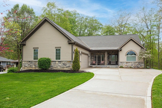 view of front of house featuring stone siding, a garage, driveway, and a front yard