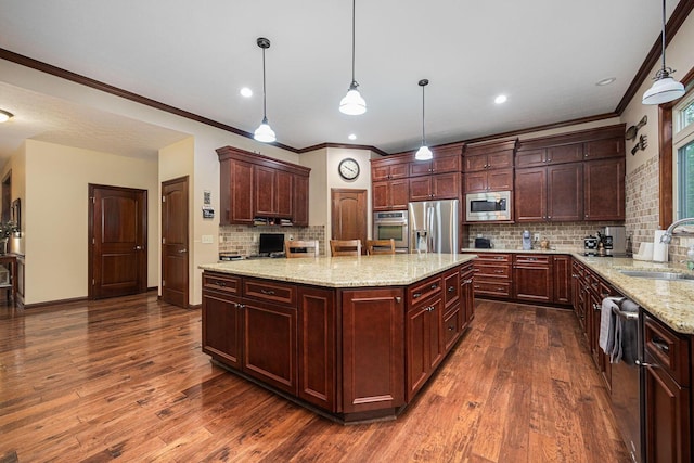kitchen with stainless steel appliances, a sink, dark wood-type flooring, ornamental molding, and a center island