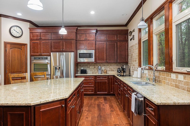 kitchen with appliances with stainless steel finishes, a sink, dark brown cabinets, crown molding, and dark wood-style flooring