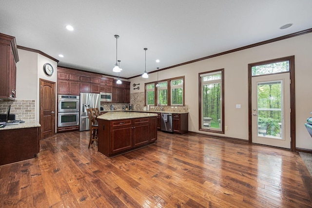 kitchen featuring stainless steel appliances, decorative backsplash, dark wood-style flooring, crown molding, and a kitchen island