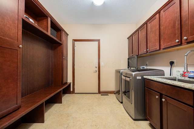 laundry area featuring separate washer and dryer, cabinet space, and baseboards