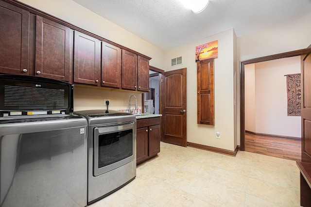 laundry area featuring washer and dryer, cabinet space, and baseboards