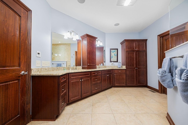 bathroom featuring double vanity, tile patterned flooring, and baseboards