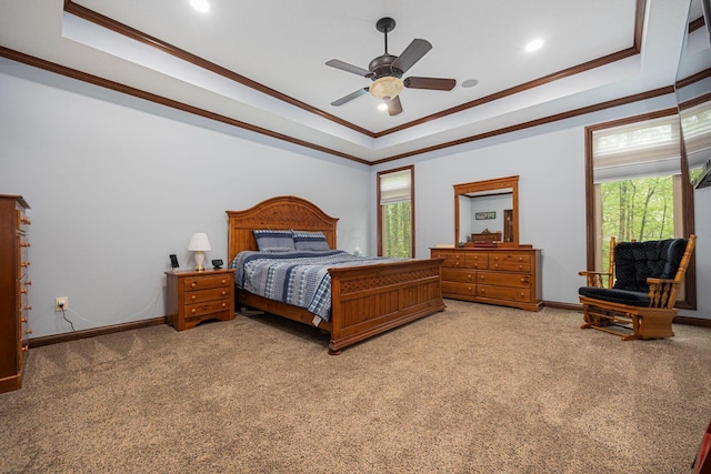 bedroom featuring a tray ceiling, crown molding, light colored carpet, multiple windows, and baseboards