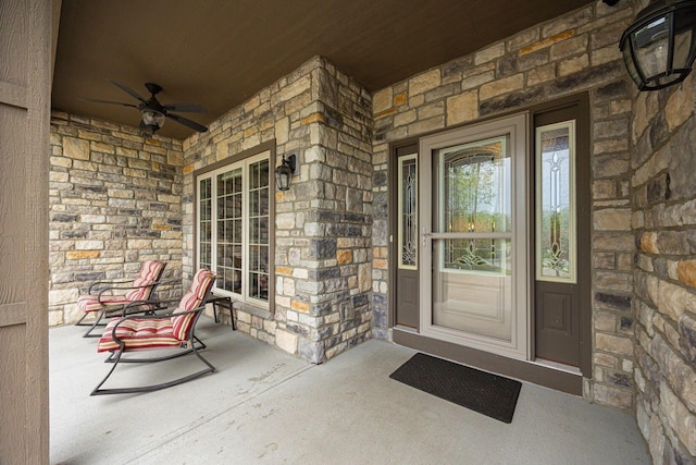 property entrance featuring covered porch, stone siding, and ceiling fan