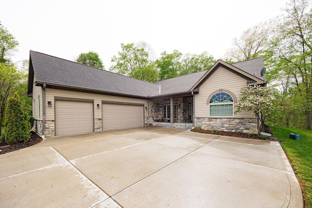 ranch-style house featuring stone siding, driveway, a garage, and roof with shingles